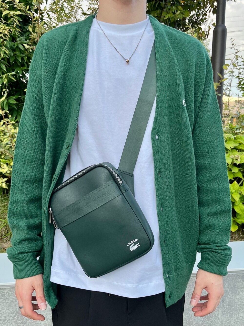 グリーン系のカーディガン/ボレロ、ホワイト系のTシャツ/カットソー、グリーン系のバッグを着用したメンズの春コーディネートの5枚目の写真