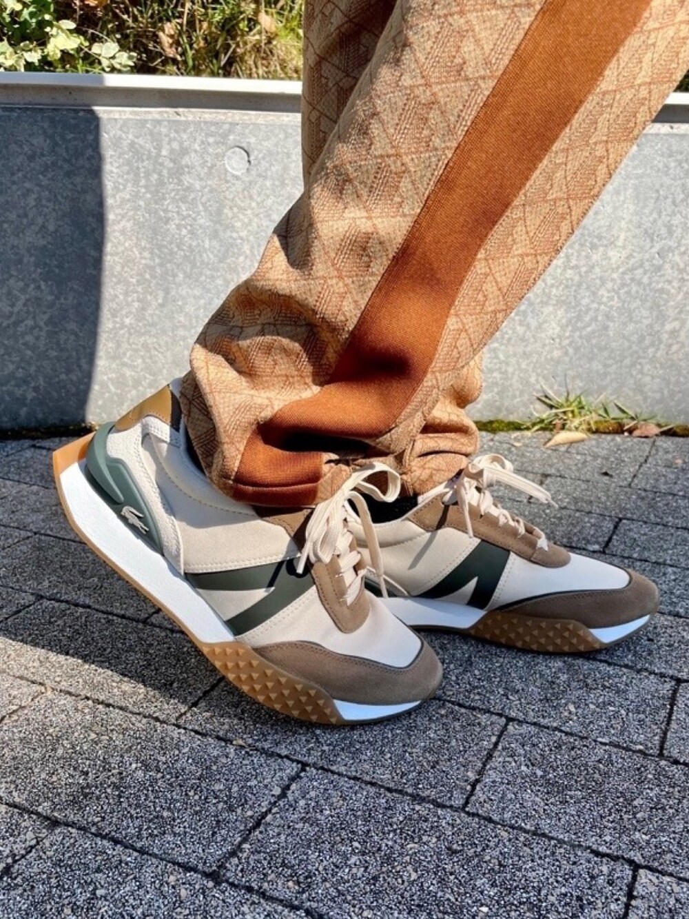 ベージュ系のその他パンツ、ベージュ系のスニーカー、ホワイト系のニット/セーターを着用したメンズの春コーディネートの6枚目の写真