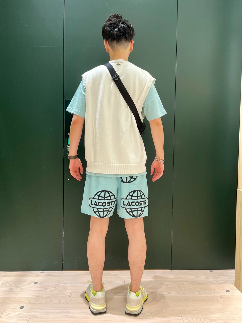 ホワイト系のベスト、ブルー系のTシャツ/カットソー、ホワイト系のスニーカーを着用したメンズの秋コーディネートの4枚目の写真