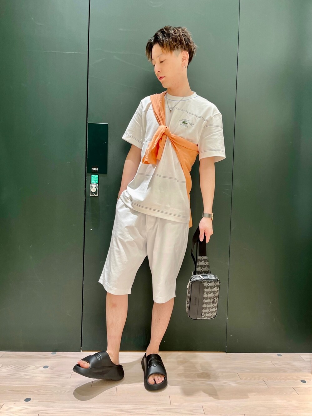 オレンジ系のシャツ/ブラウス、ホワイト系のTシャツ/カットソー、グレー系のボディバッグ/ウエストポーチを着用したメンズの春コーディネートの3枚目の写真