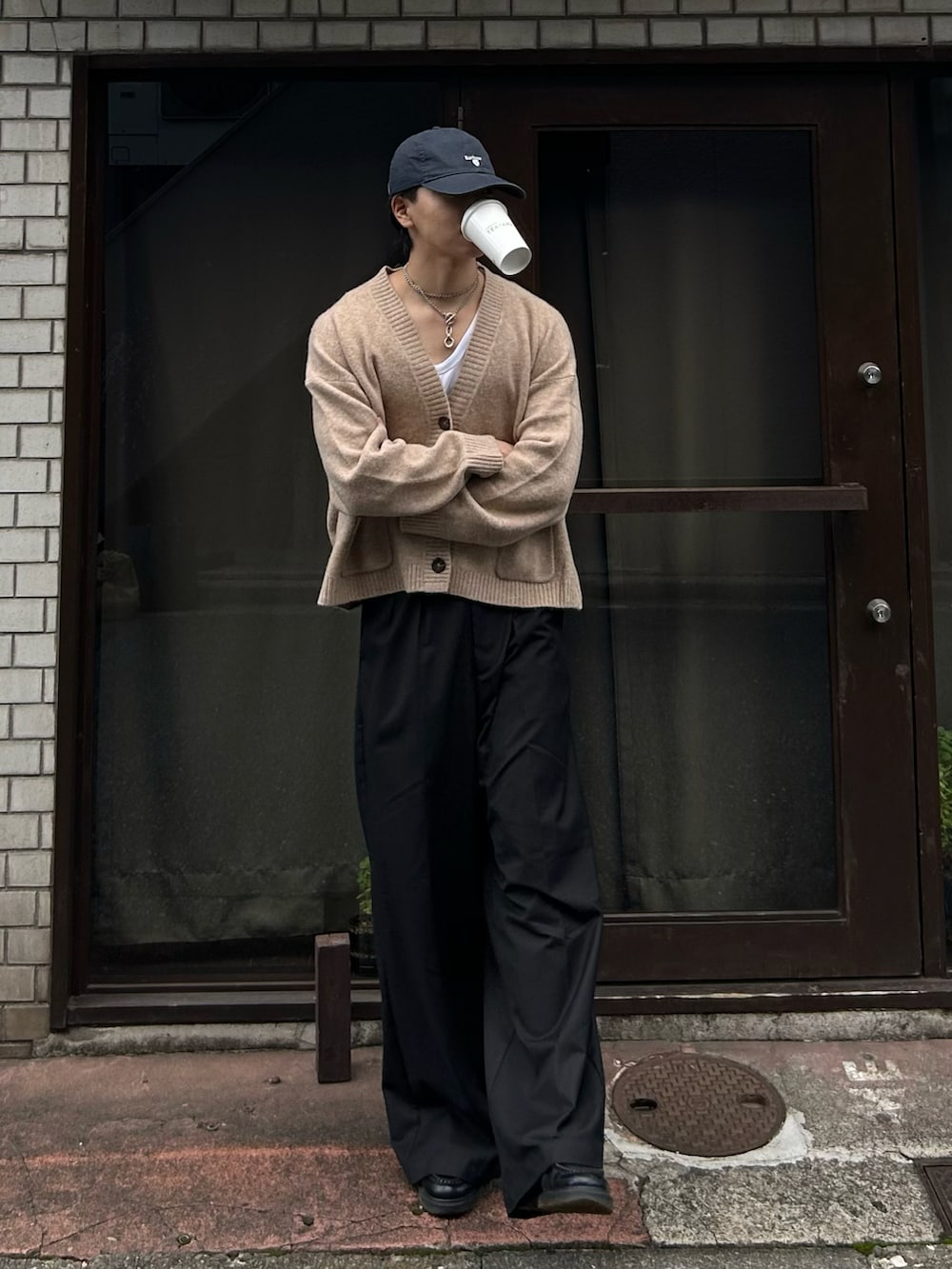 ブラック系のスラックス、ブラック系のローファー、ベージュ系のカーディガン/ボレロを着用したメンズの秋コーディネートの2枚目の写真
