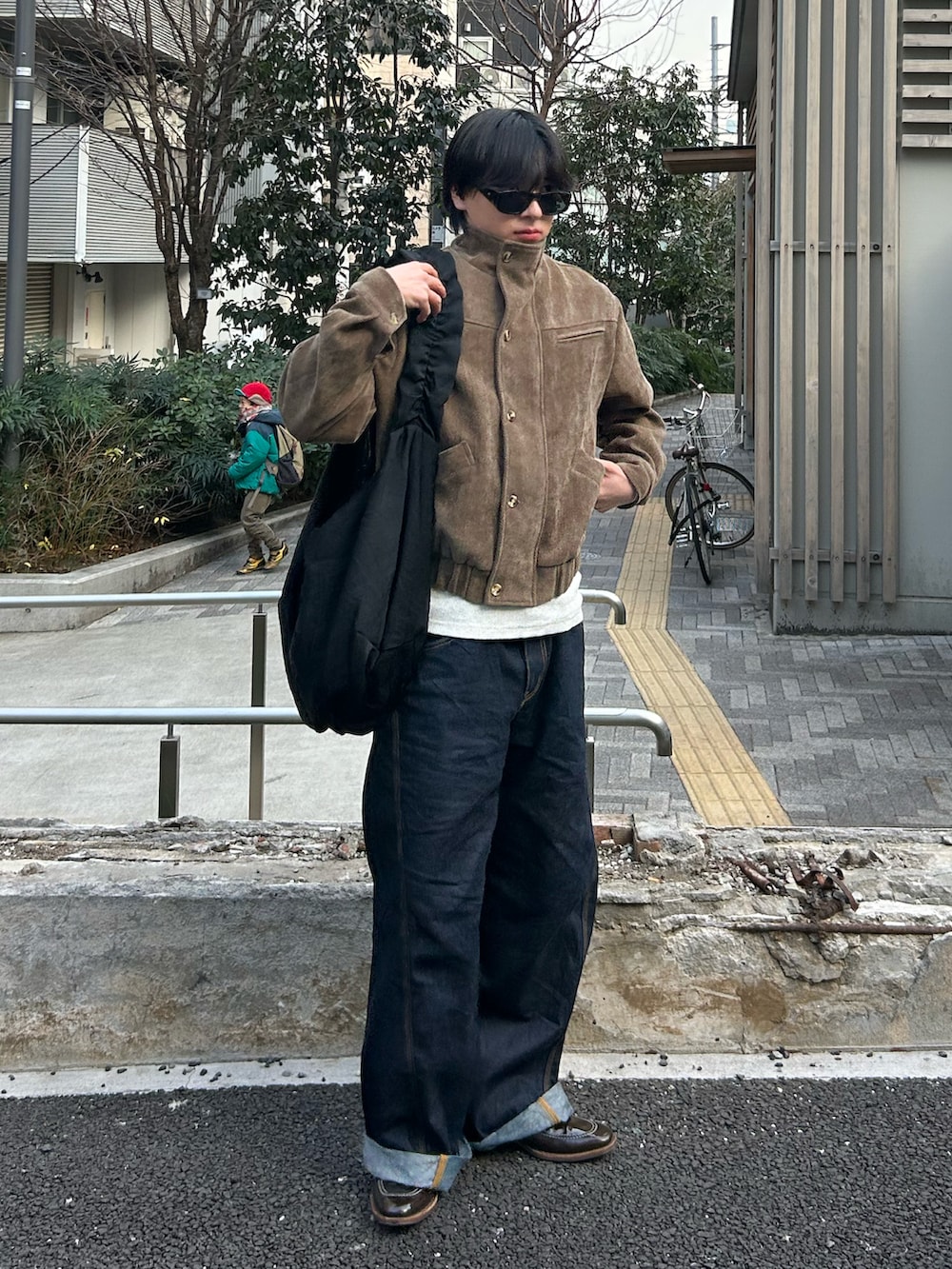 ブルー系のデニムパンツ、ブラック系のショルダーバッグ、ホワイト系のタンクトップを着用したメンズの冬コーディネートの2枚目の写真