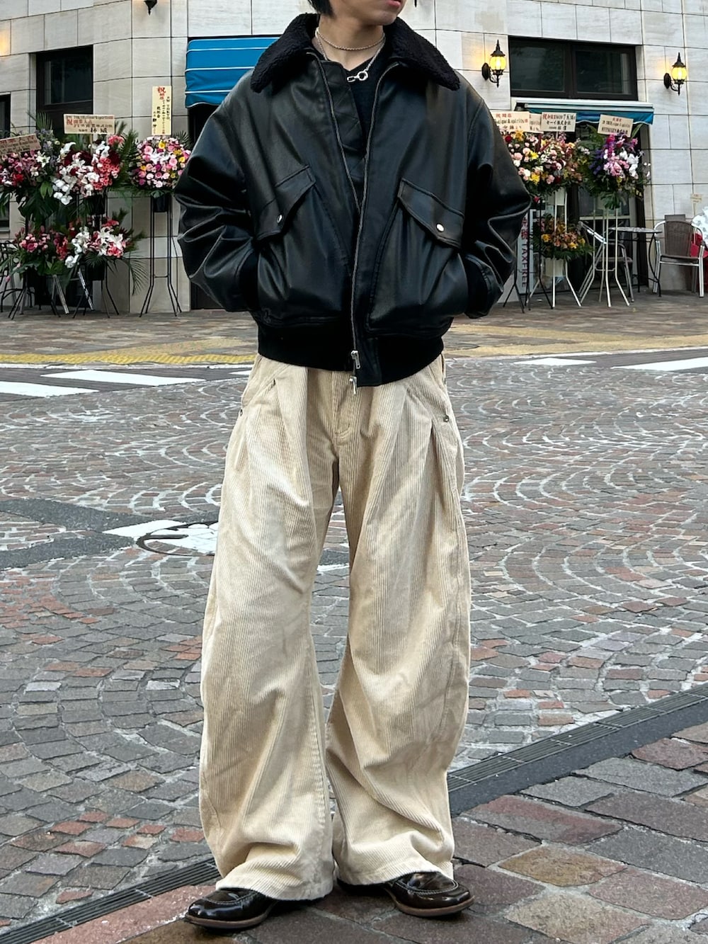 ベージュ系のスラックス、ブラウン系のローファー、グレー系のニット/セーターを着用したメンズの冬コーディネートの2枚目の写真