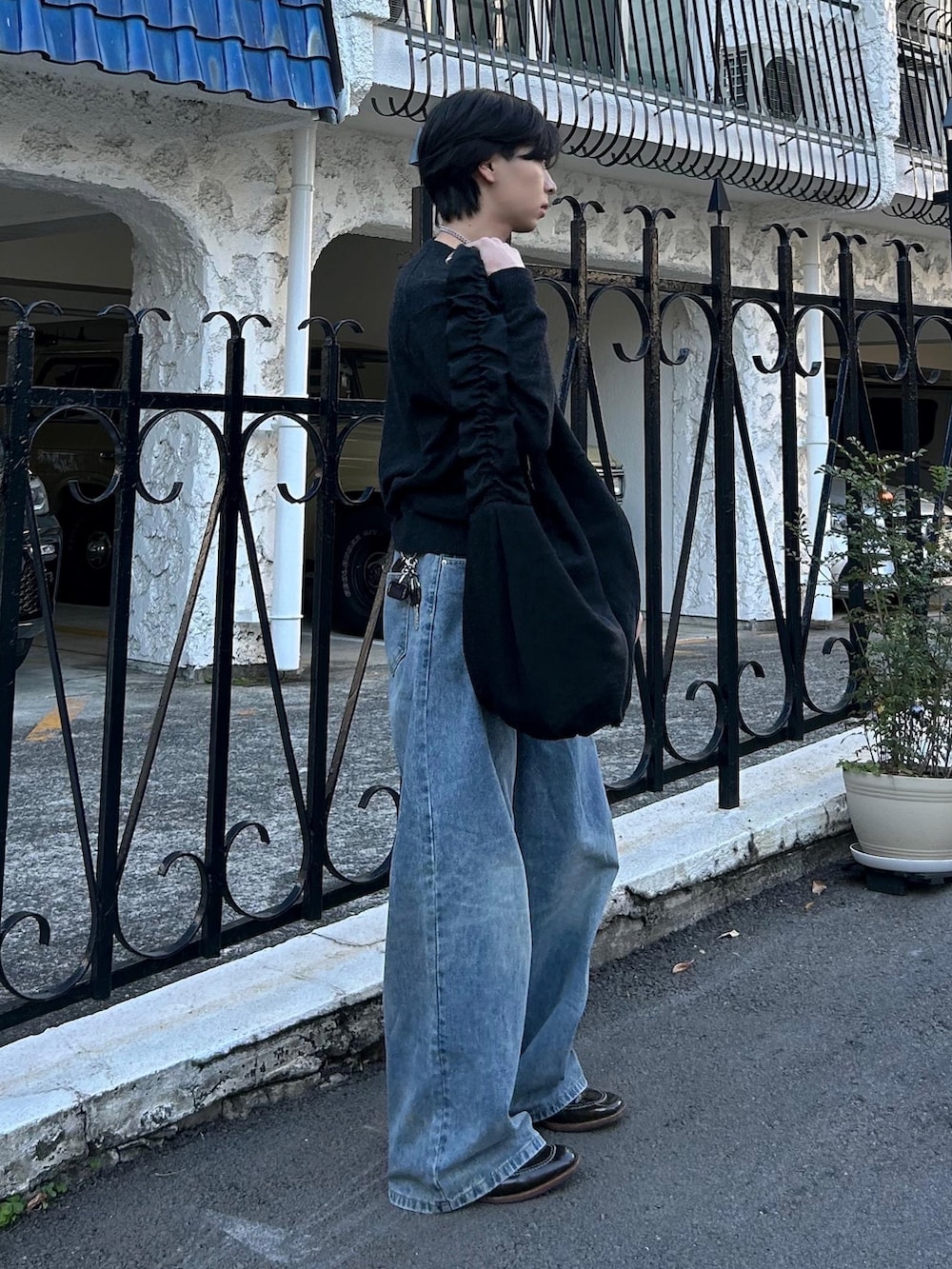 グレー系のニット/セーター、ブルー系のデニムパンツ、ブラウン系のローファーを着用したメンズの冬コーディネートの2枚目の写真