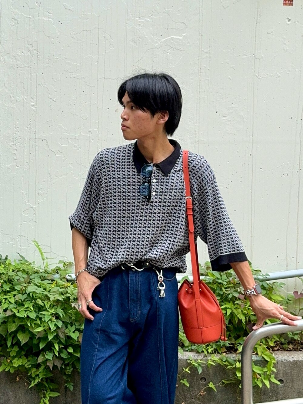 ブルー系のデニムパンツ、ブラック系のブーツ、グレー系のポロシャツを着用したメンズの夏コーディネートの2枚目の写真