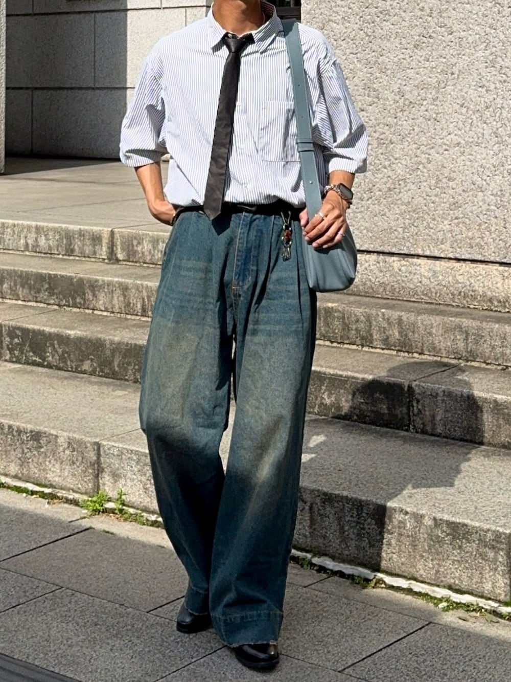 ホワイト系のシャツ/ブラウス、ブルー系のデニムパンツ、ブラック系のドレスシューズを着用したメンズの夏コーディネートの4枚目の写真