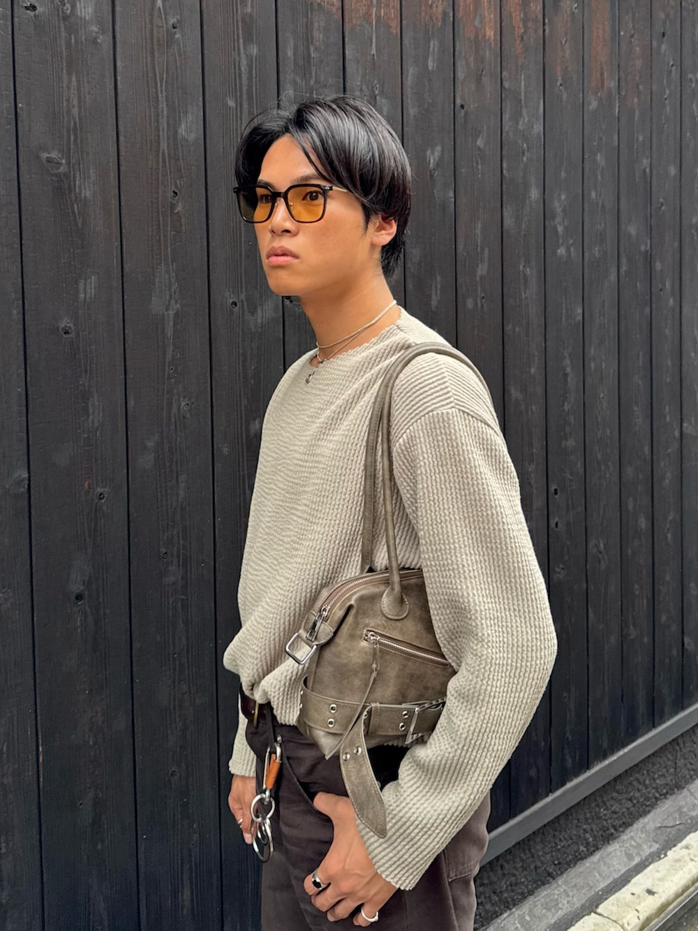 グリーン系のTシャツ/カットソー、ブラウン系のデニムパンツ、ブラウン系のショルダーバッグを着用したメンズの秋コーディネートの2枚目の写真