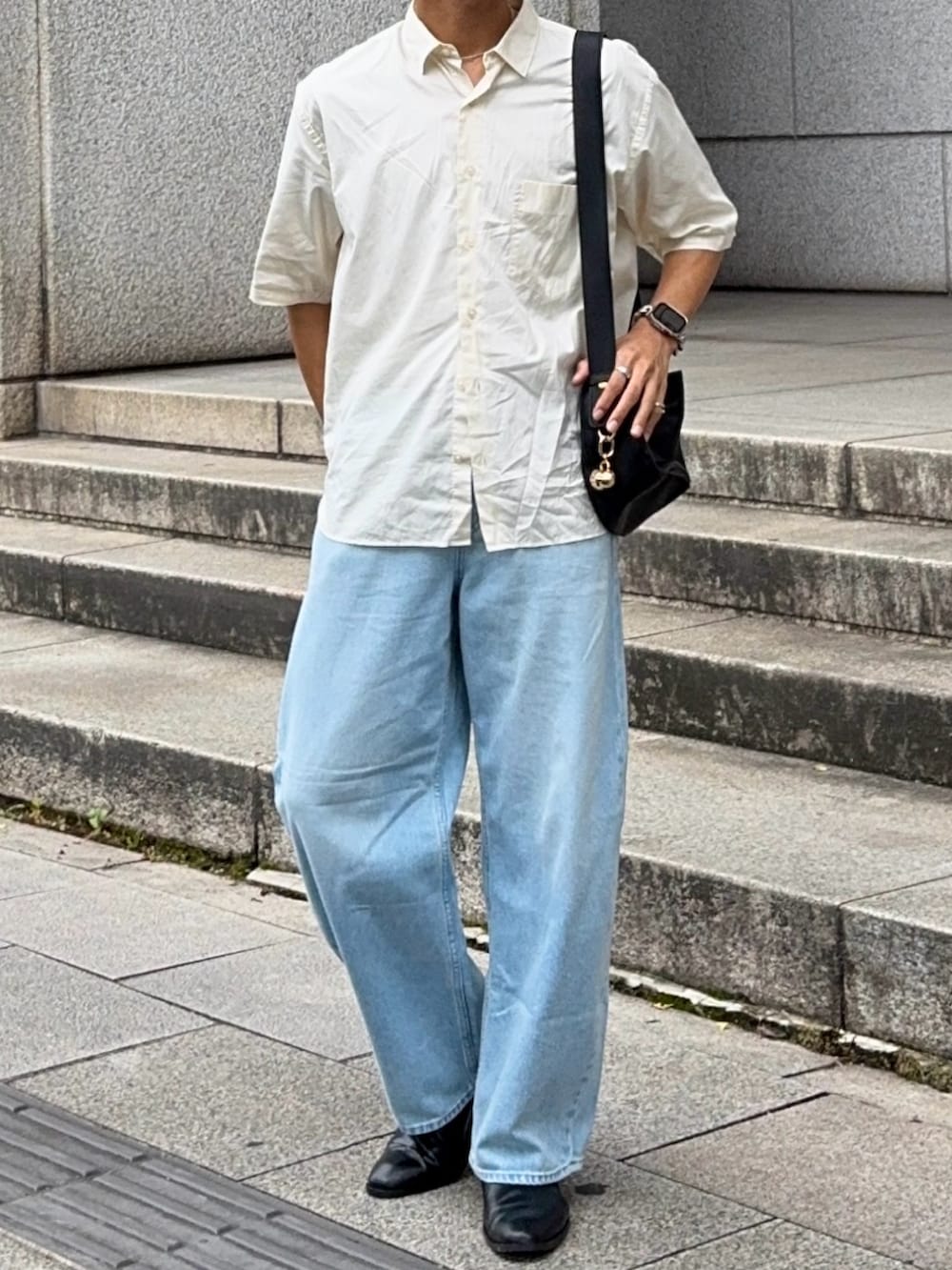 ブラック系のハンドバッグ、ベージュ系のシャツ/ブラウス、ブルー系のデニムパンツを着用したメンズの夏コーディネートの4枚目の写真