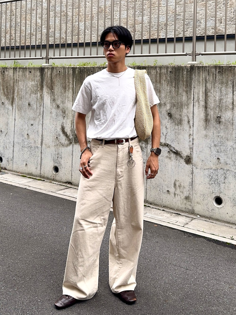 ホワイト系のTシャツ/カットソー、ホワイト系のデニムパンツ、ベージュ系のハンドバッグを着用したメンズの夏コーディネートの3枚目の写真