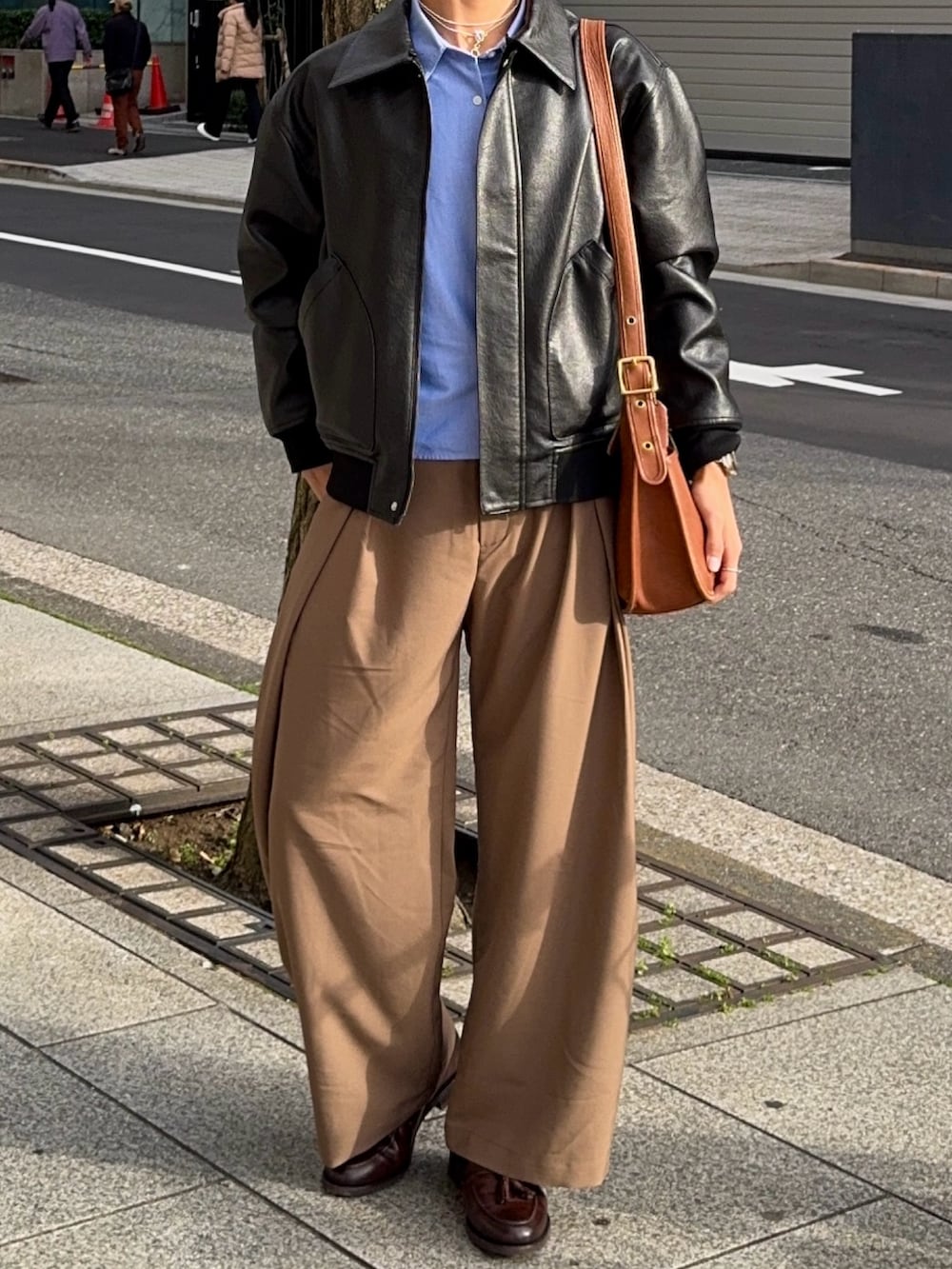 ブラウン系のスラックス、ブラウン系のローファー、ブラック系のその他アウターを着用したメンズの春コーディネートの4枚目の写真