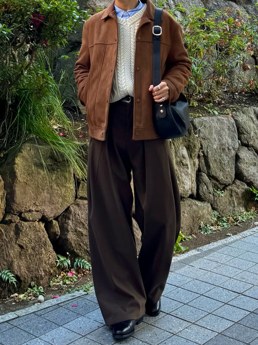 ブラック系のドレスシューズ、ブラウン系のスラックス、ブラック系のハンドバッグを着用したメンズの冬コーディネートの4枚目の写真