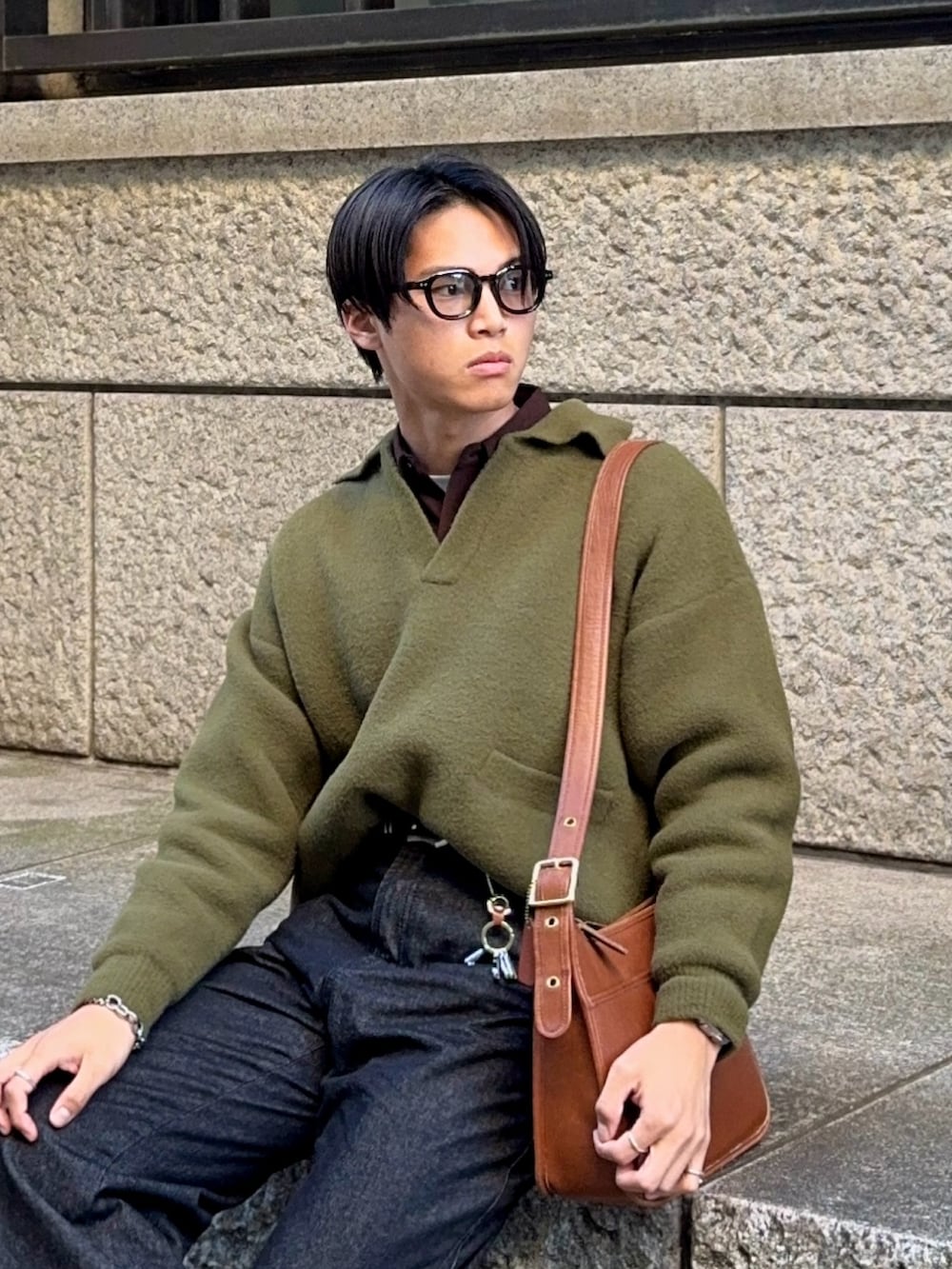 グリーン系のニット/セーター、ブラウン系のシャツ/ブラウス、ブラック系のデニムパンツを着用したメンズの冬コーディネートの2枚目の写真