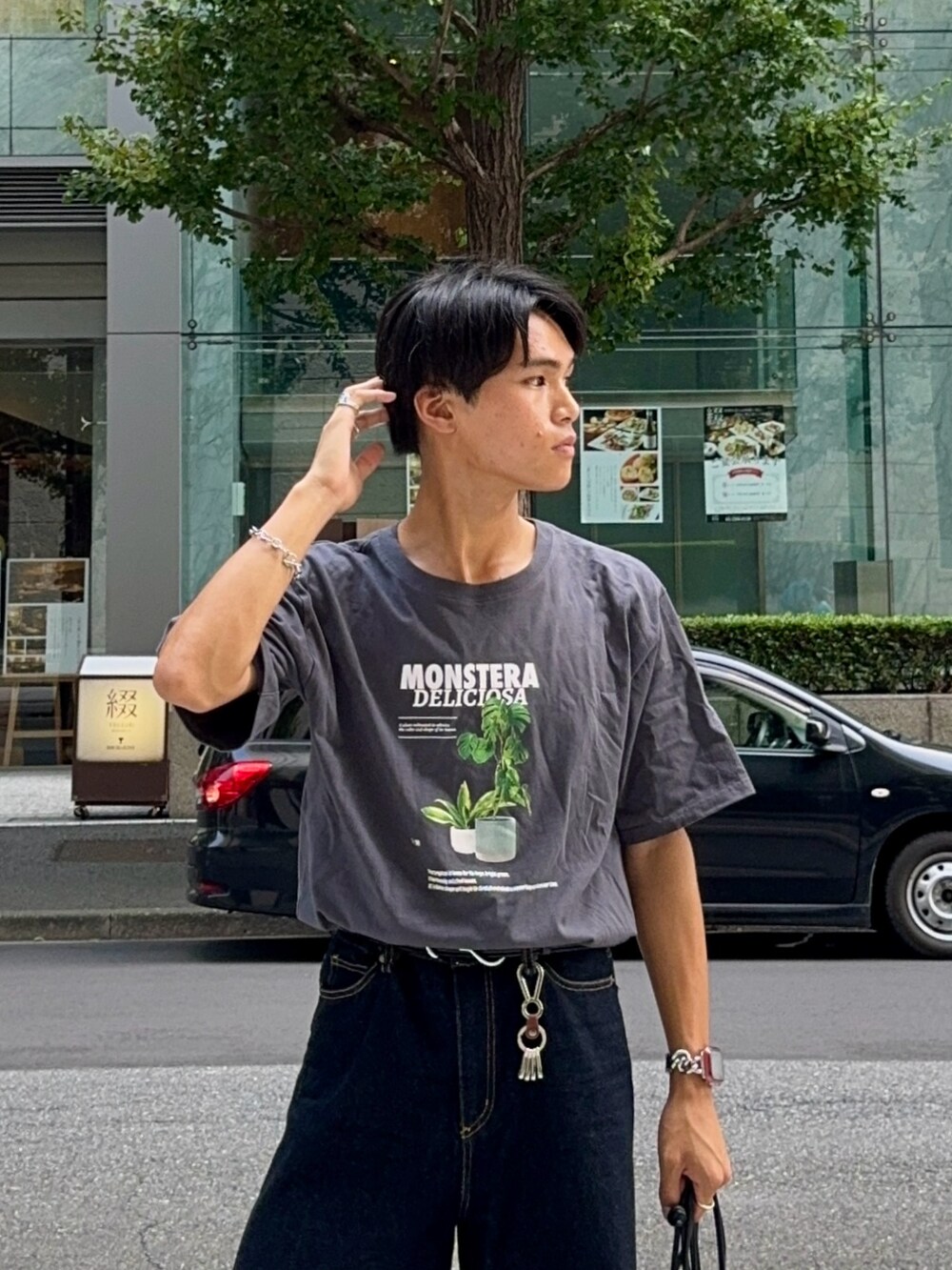 ブラック系のバッグ、ブルー系のデニムパンツ、グレー系のTシャツ/カットソーを着用したメンズの夏コーディネートの2枚目の写真