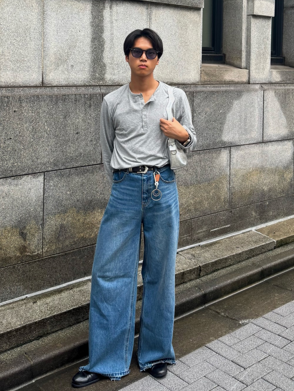 グレー系のTシャツ/カットソー、その他のデニムパンツ、シルバー系のショルダーバッグを着用したメンズの秋コーディネートの5枚目の写真