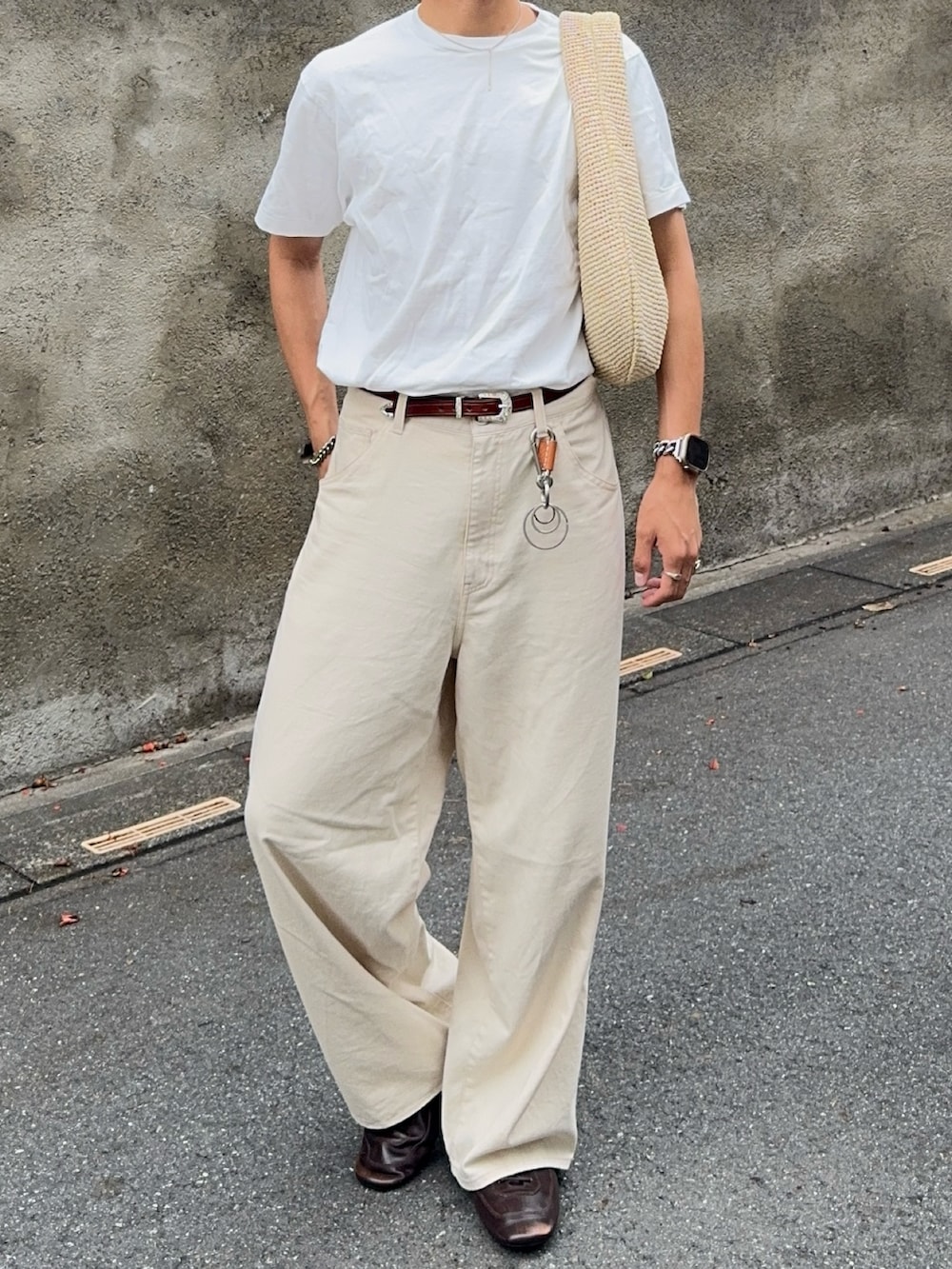 ホワイト系のTシャツ/カットソー、ホワイト系のデニムパンツ、ベージュ系のハンドバッグを着用したメンズの夏コーディネートの4枚目の写真