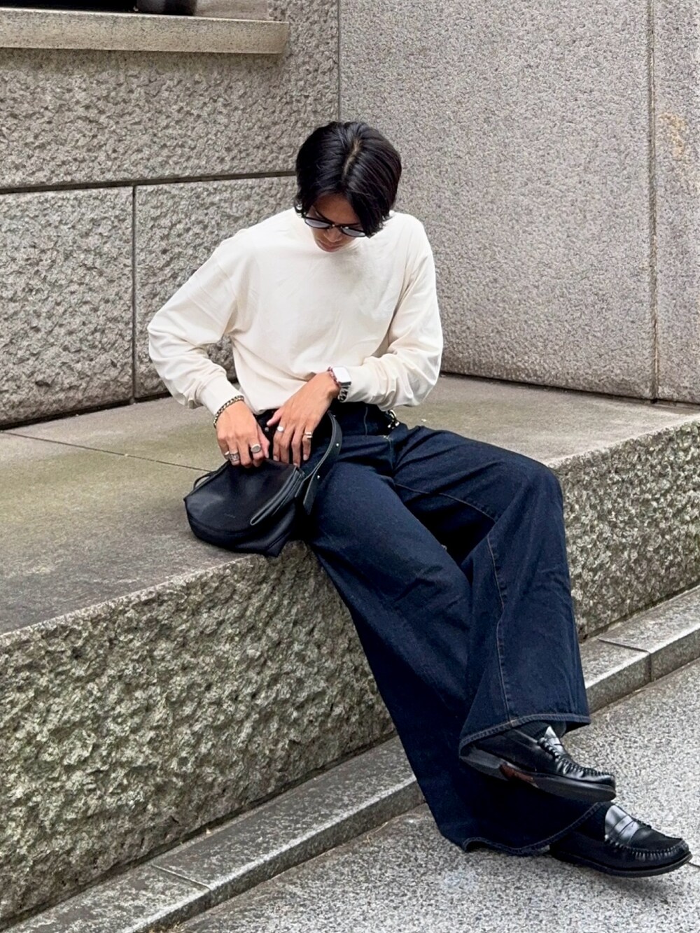 ベージュ系のTシャツ/カットソー、ブラック系のローファー、ブルー系のデニムパンツを着用したメンズの秋コーディネートの5枚目の写真