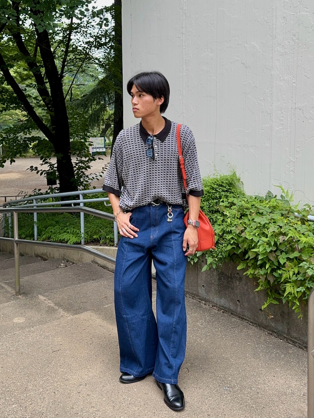 ブルー系のデニムパンツ、ブラック系のブーツ、グレー系のポロシャツを着用したメンズの夏コーディネートの5枚目の写真