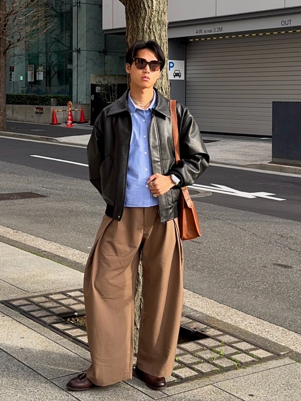 ブラウン系のスラックス、ブラウン系のローファー、ブラック系のその他アウターを着用したメンズの春コーディネートの5枚目の写真