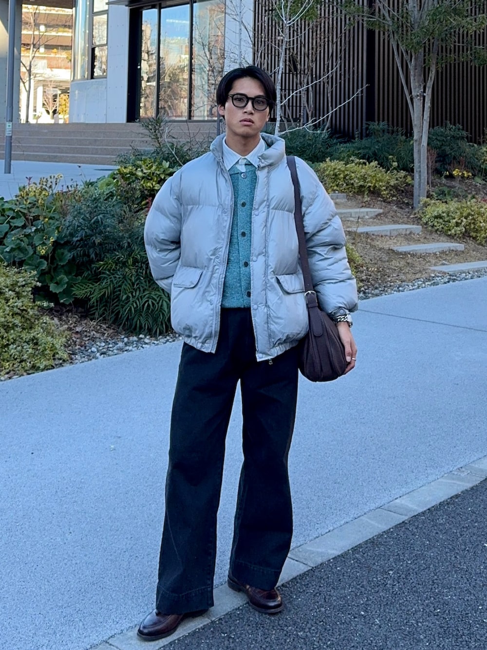 ブラック系のデニムパンツ、ブラウン系のローファー、グレー系のダウンジャケット/コートを着用したメンズの冬コーディネートの5枚目の写真