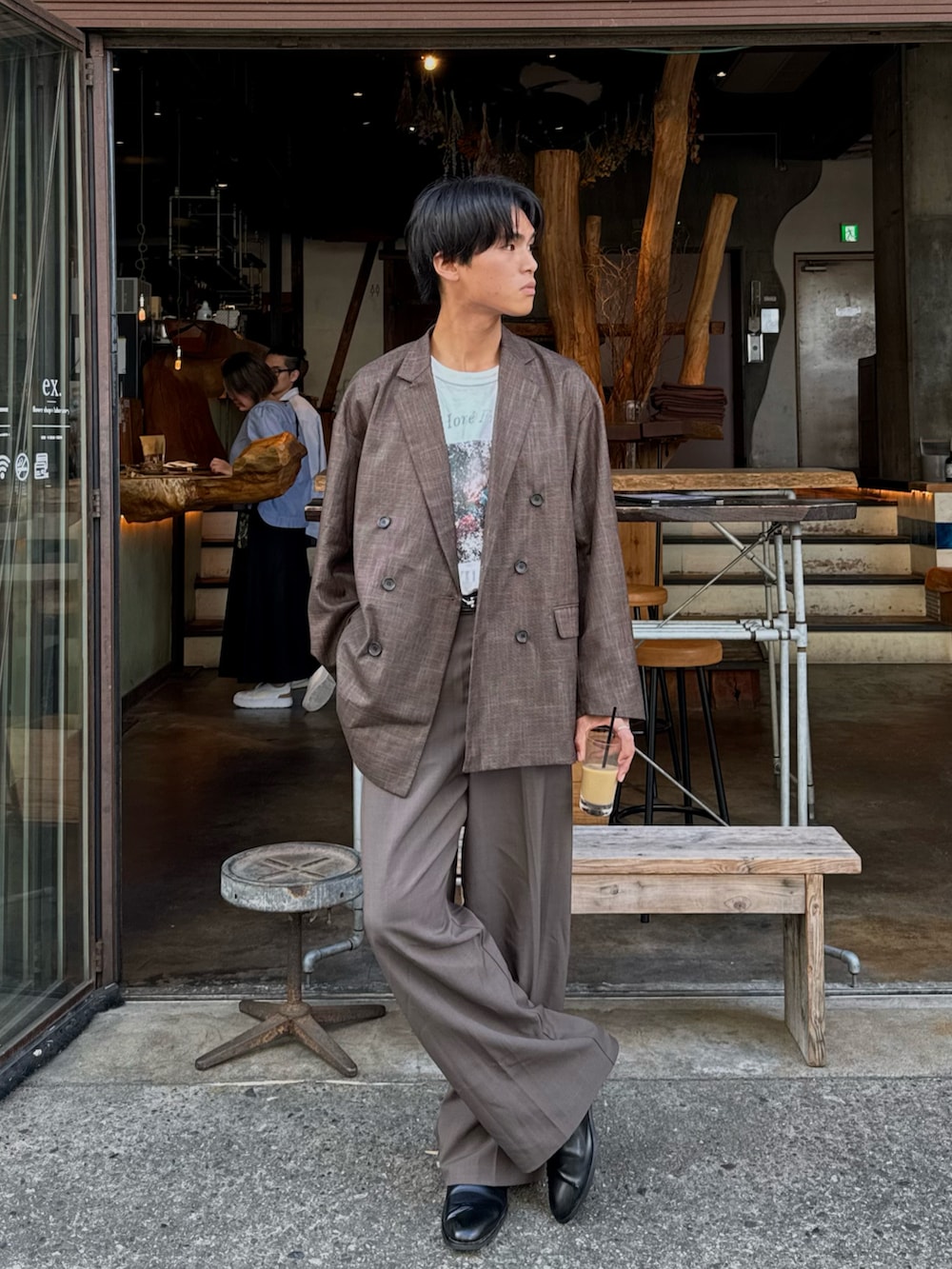 ブラウン系のテーラードジャケット、ホワイト系のTシャツ/カットソー、ブラウン系のスラックスを着用したメンズの秋コーディネートの3枚目の写真