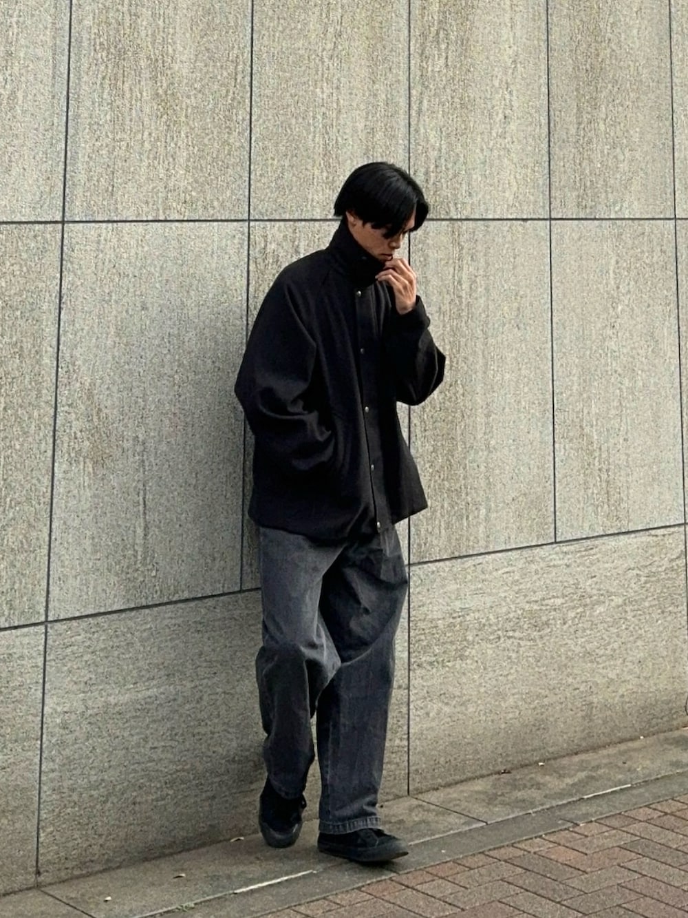 ブラック系のスニーカー、グレー系のデニムパンツ、ブラック系のブルゾンを着用したメンズの冬コーディネートの3枚目の写真