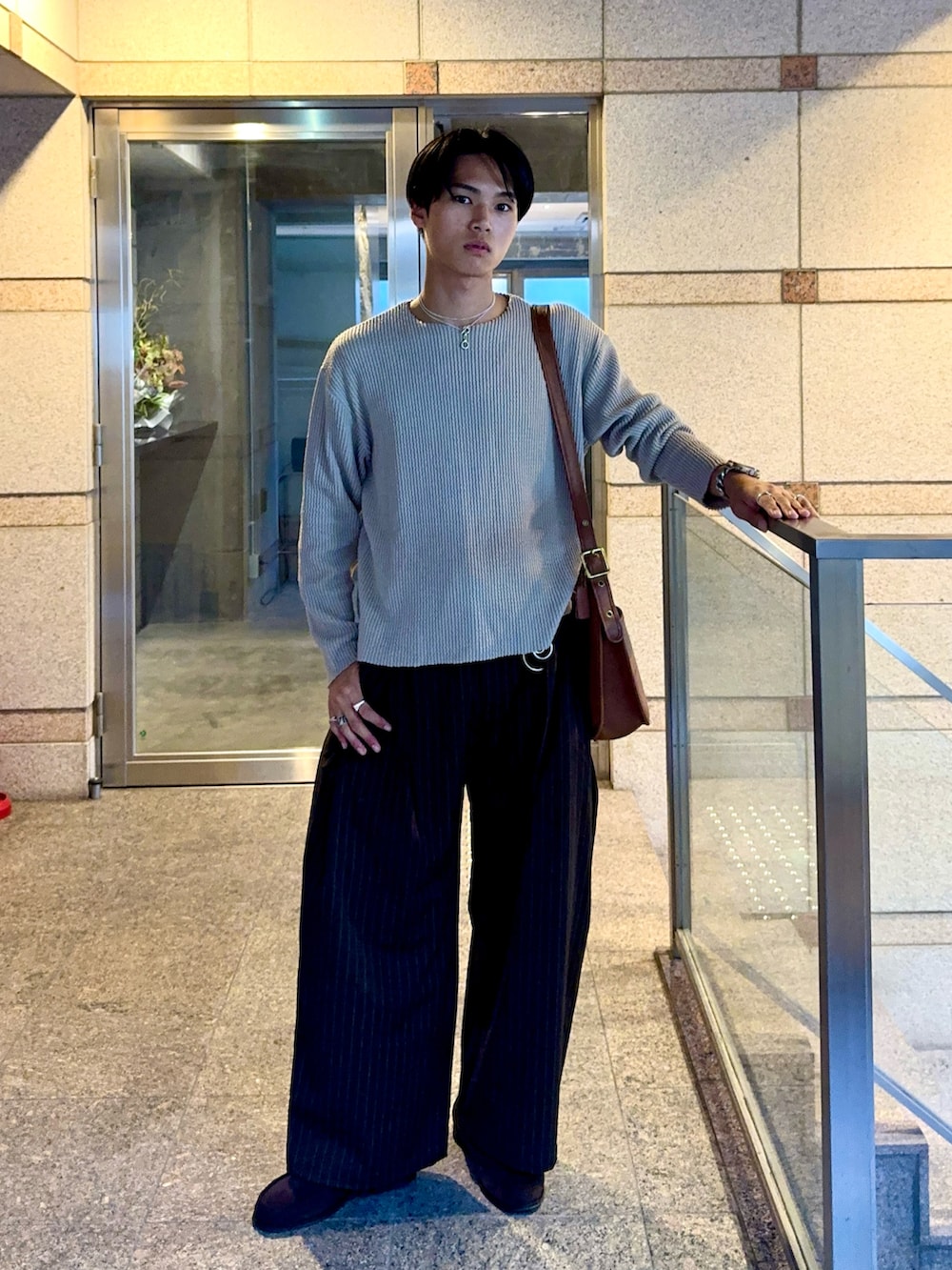 グリーン系のTシャツ/カットソー、ブラウン系のスラックス、ブラウン系のショルダーバッグを着用したメンズの夏コーディネートの5枚目の写真