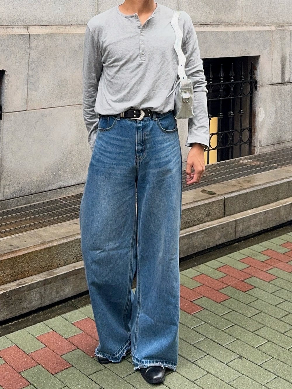 グレー系のTシャツ/カットソー、その他のデニムパンツ、シルバー系のショルダーバッグを着用したメンズの秋コーディネートの4枚目の写真