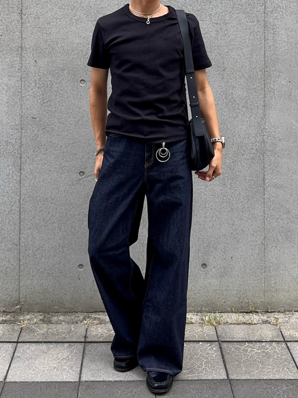 ブラック系のTシャツ/カットソー、ブルー系のデニムパンツ、ブラック系のローファーを着用したメンズの夏コーディネートの4枚目の写真