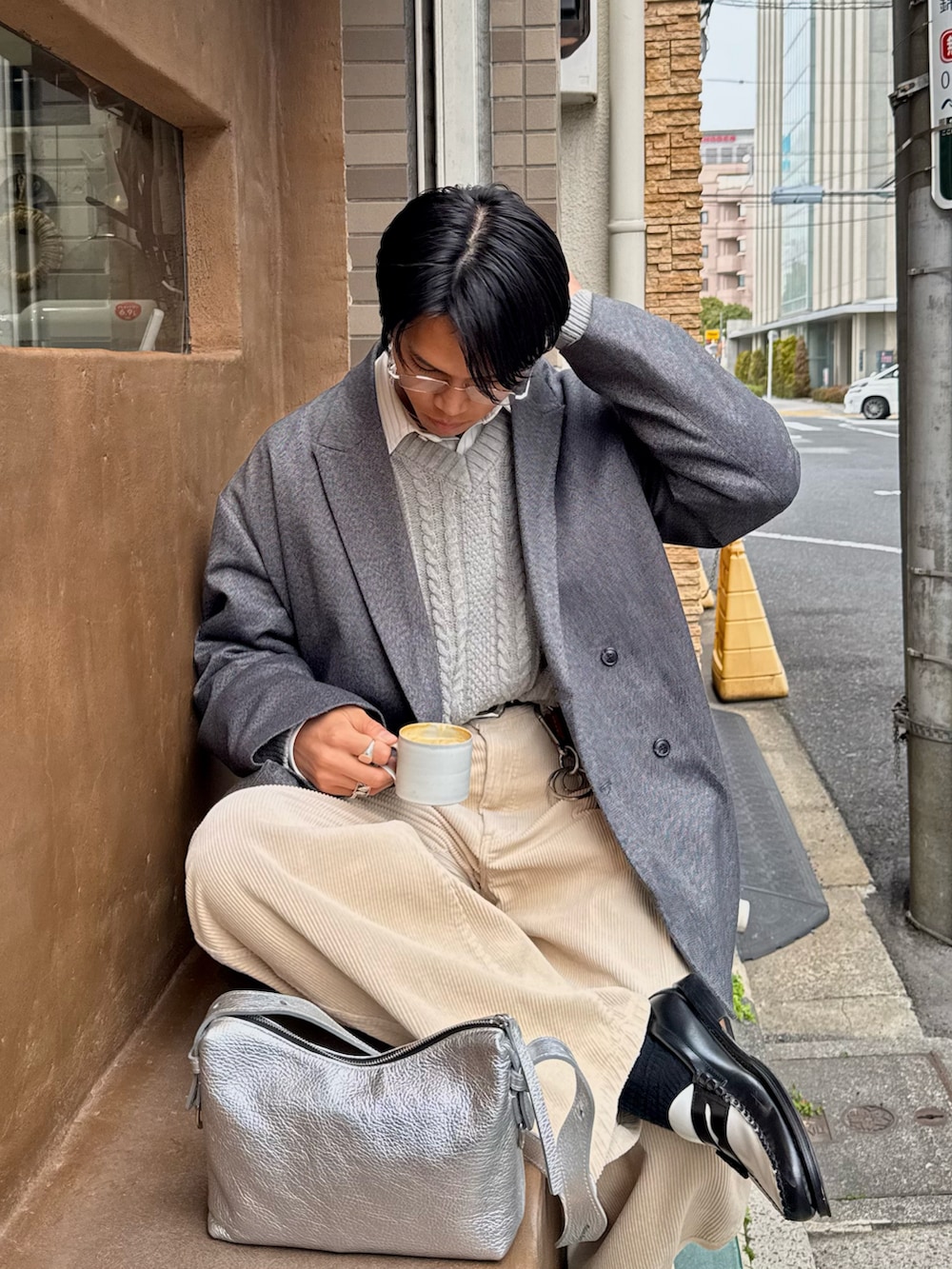 ベージュ系のスラックス、ブラック系のローファー、グレー系のテーラードジャケットを着用したメンズの春コーディネートの2枚目の写真