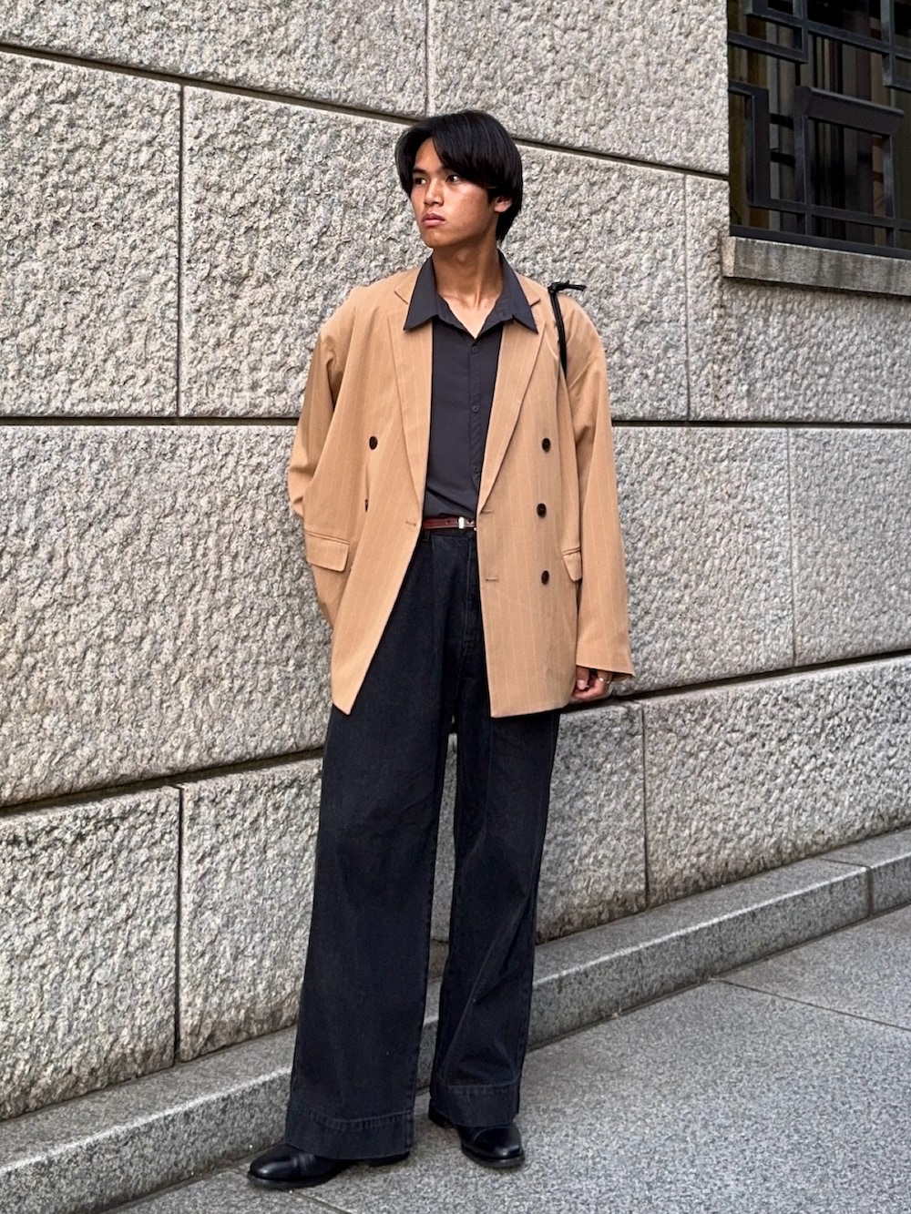 ブラック系のデニムパンツ、グレー系のシャツ/ブラウス、ベージュ系のテーラードジャケットを着用したメンズの秋コーディネートの3枚目の写真