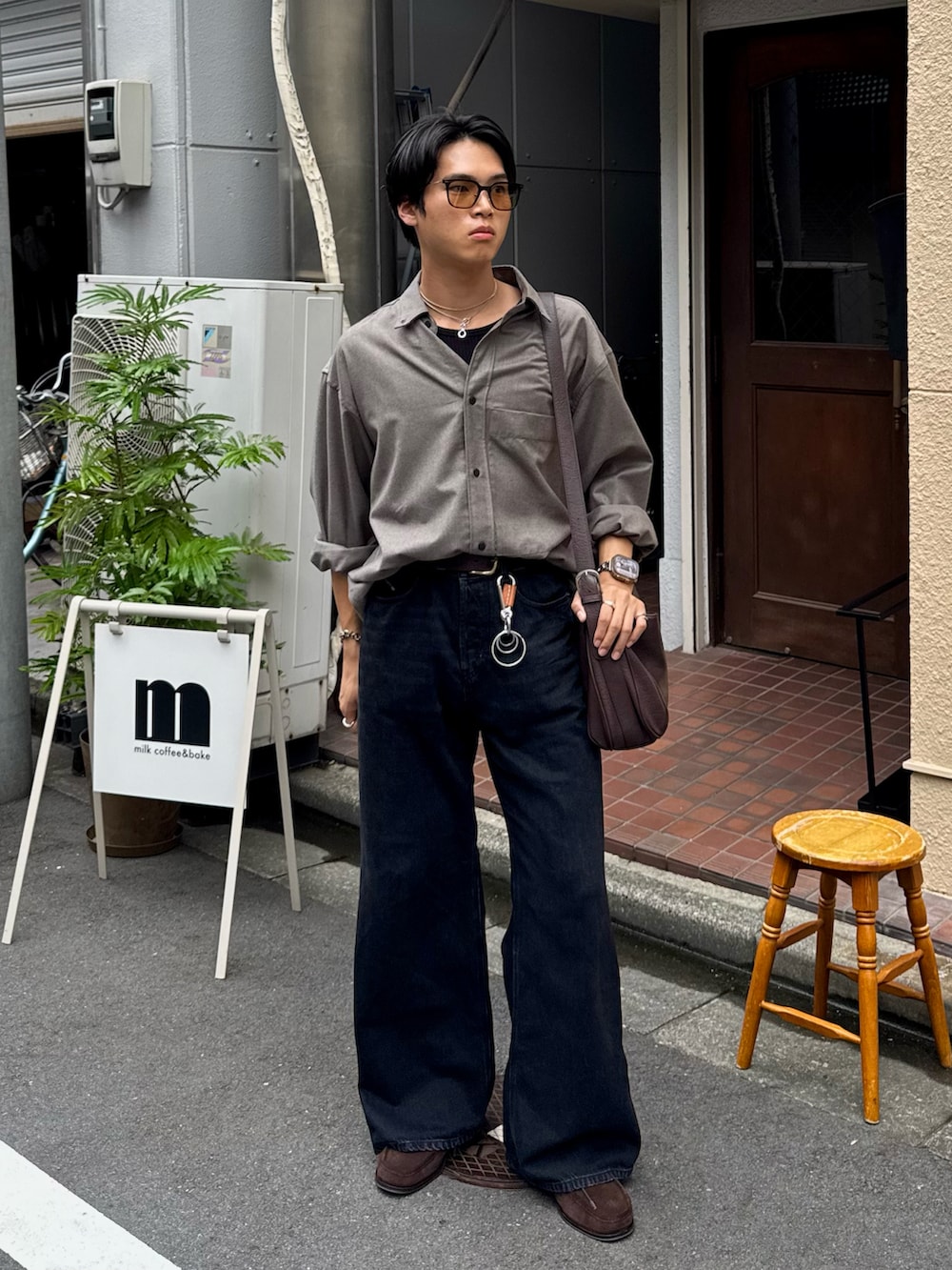 ブラック系のタンクトップ、ブラック系のデニムパンツ、ブラウン系のショルダーバッグを着用したメンズの秋コーディネートの3枚目の写真