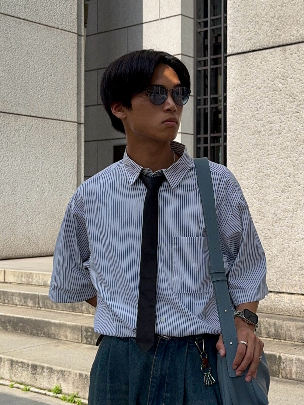 ホワイト系のシャツ/ブラウス、ブルー系のデニムパンツ、ブラック系のドレスシューズを着用したメンズの夏コーディネートの2枚目の写真