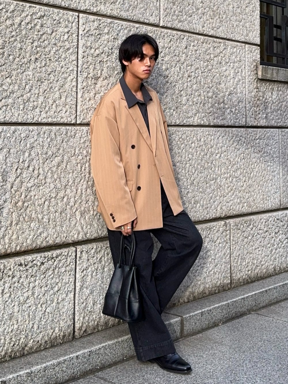 ブラック系のデニムパンツ、グレー系のシャツ/ブラウス、ベージュ系のテーラードジャケットを着用したメンズの秋コーディネートの5枚目の写真