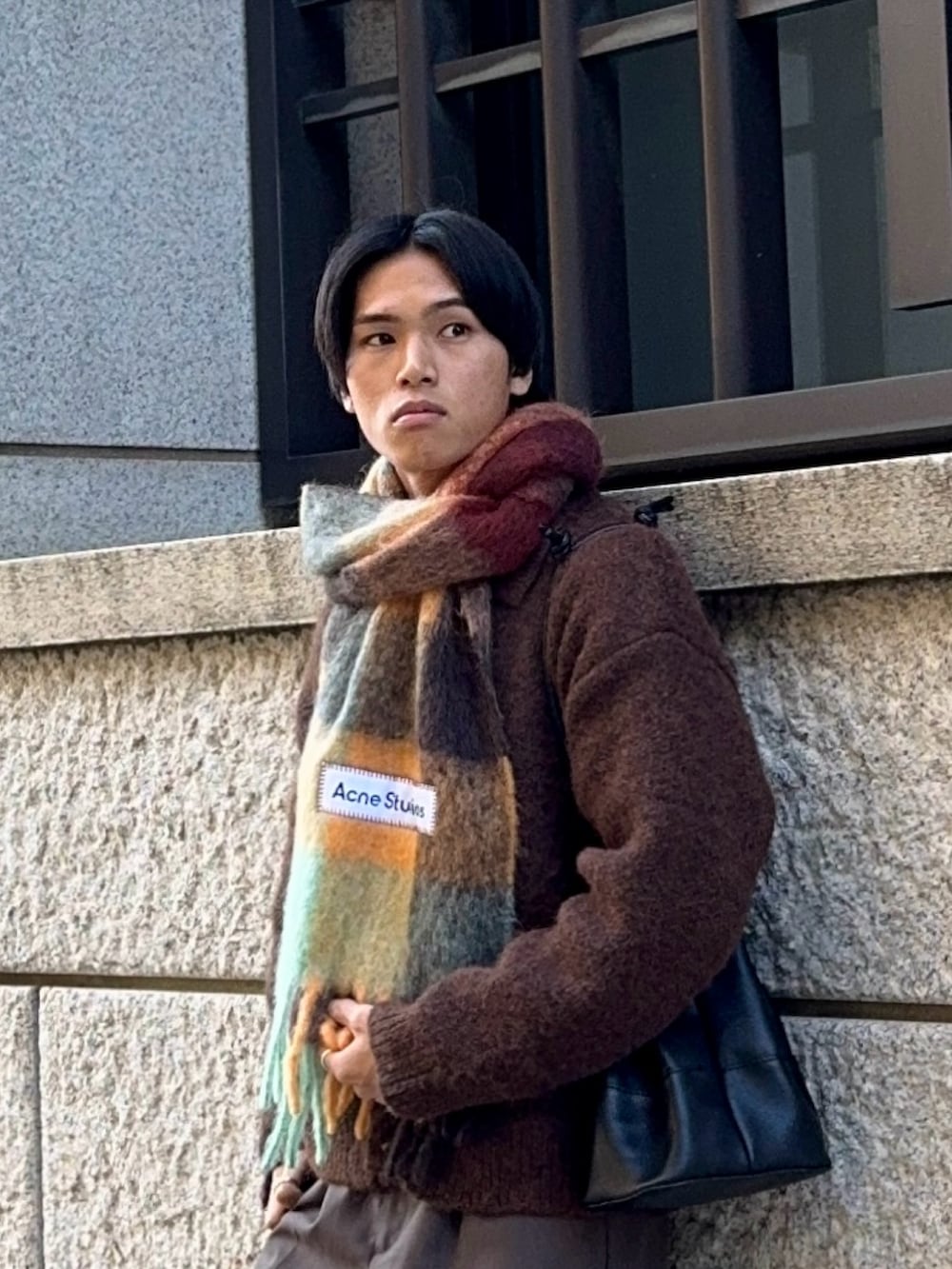 ブラウン系のスラックス、ブラック系のドレスシューズ、ブラウン系のカーディガン/ボレロを着用したメンズの冬コーディネートの2枚目の写真