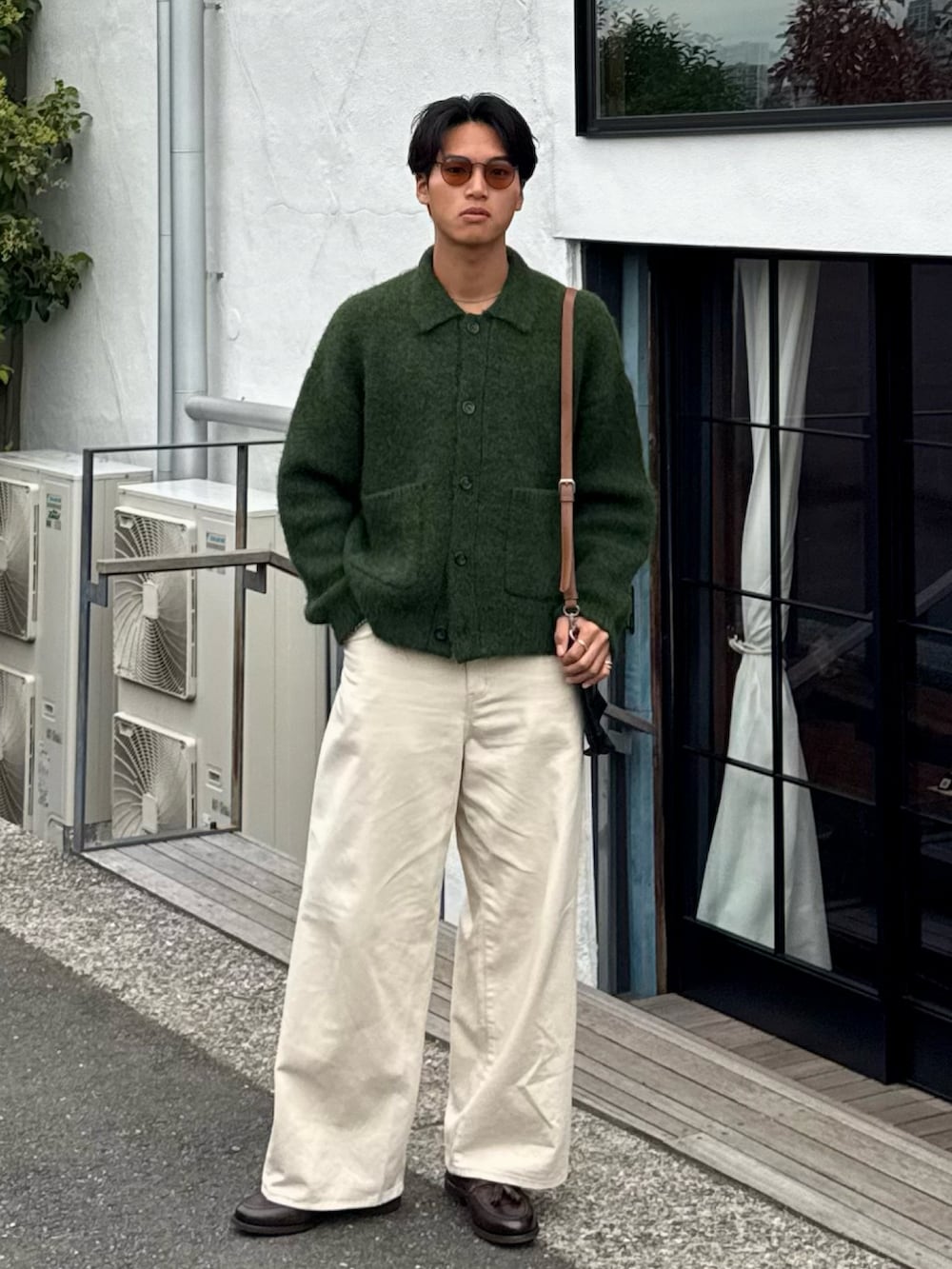 グリーン系のカーディガン/ボレロ、ホワイト系のデニムパンツ、ブラウン系のローファーを着用したメンズの秋コーディネートの3枚目の写真