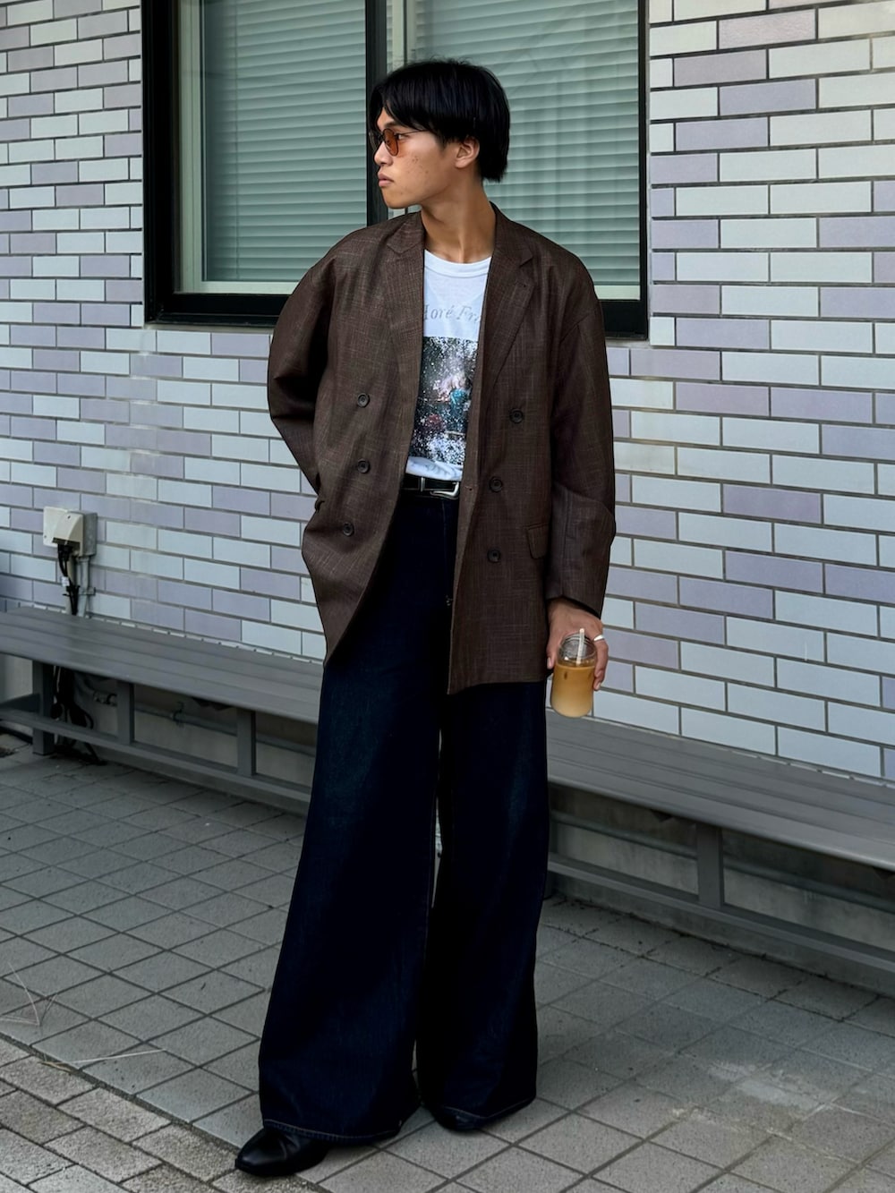 ブラウン系のテーラードジャケット、ホワイト系のTシャツ/カットソー、ブルー系のデニムパンツを着用したメンズの秋コーディネートの3枚目の写真