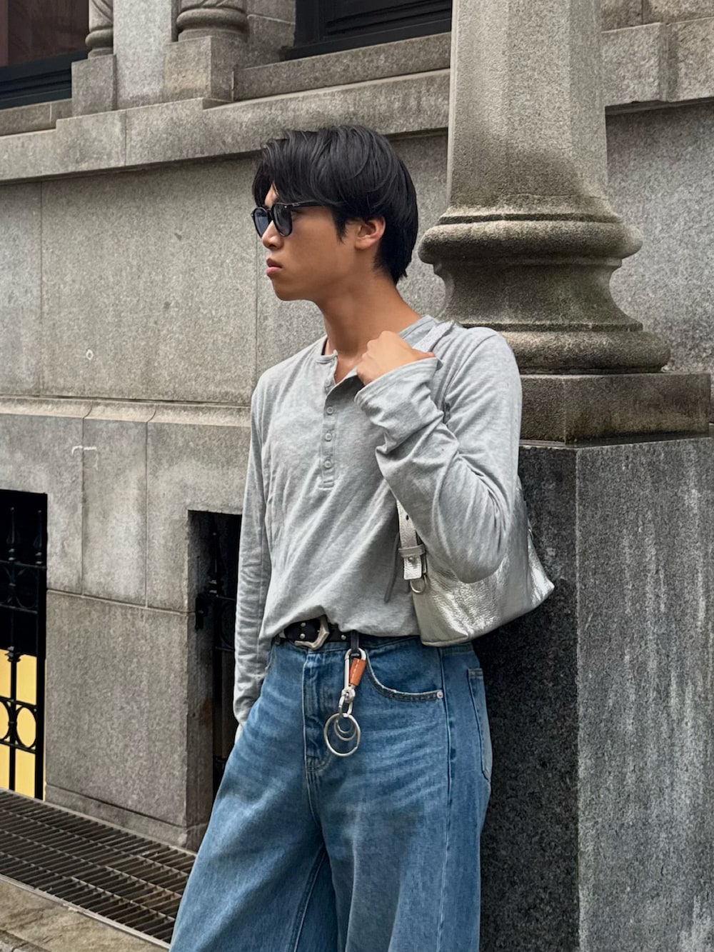 グレー系のTシャツ/カットソー、その他のデニムパンツ、シルバー系のショルダーバッグを着用したメンズの秋コーディネートの2枚目の写真