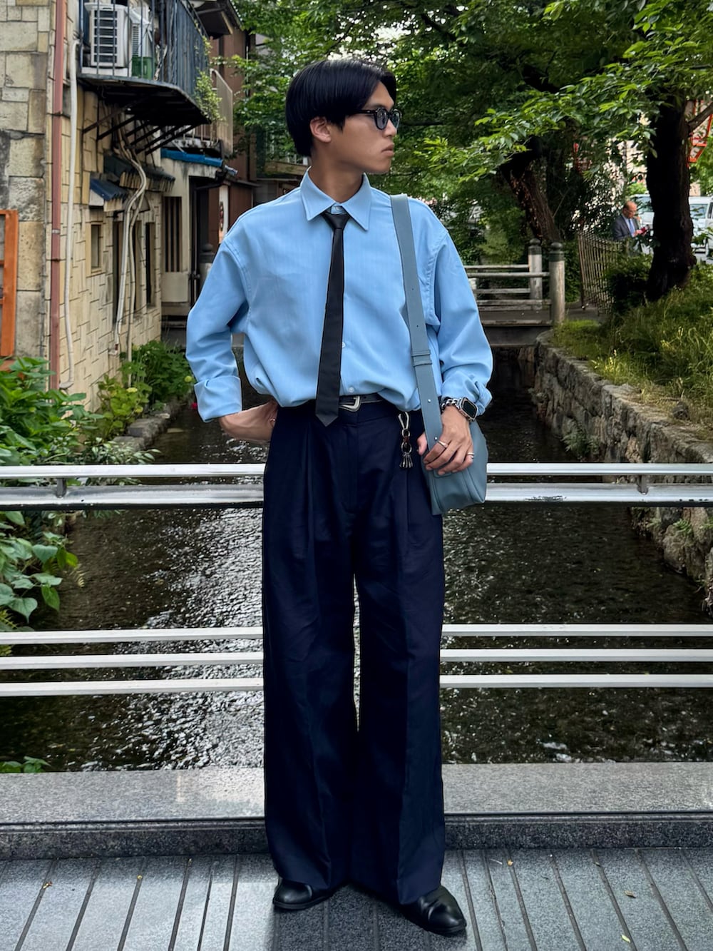 ブルー系のシャツ/ブラウス、ブラック系のネクタイ、ブルー系のショルダーバッグを着用したメンズの春コーディネートの5枚目の写真