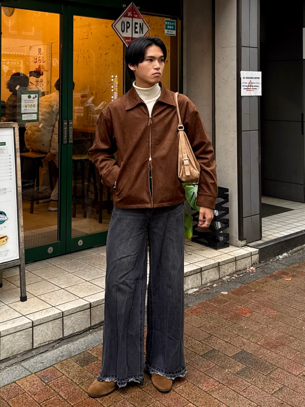 ブラウン系のブルゾン、ブラック系のデニムパンツ、ホワイト系のニット/セーターを着用したメンズの冬コーディネートの3枚目の写真