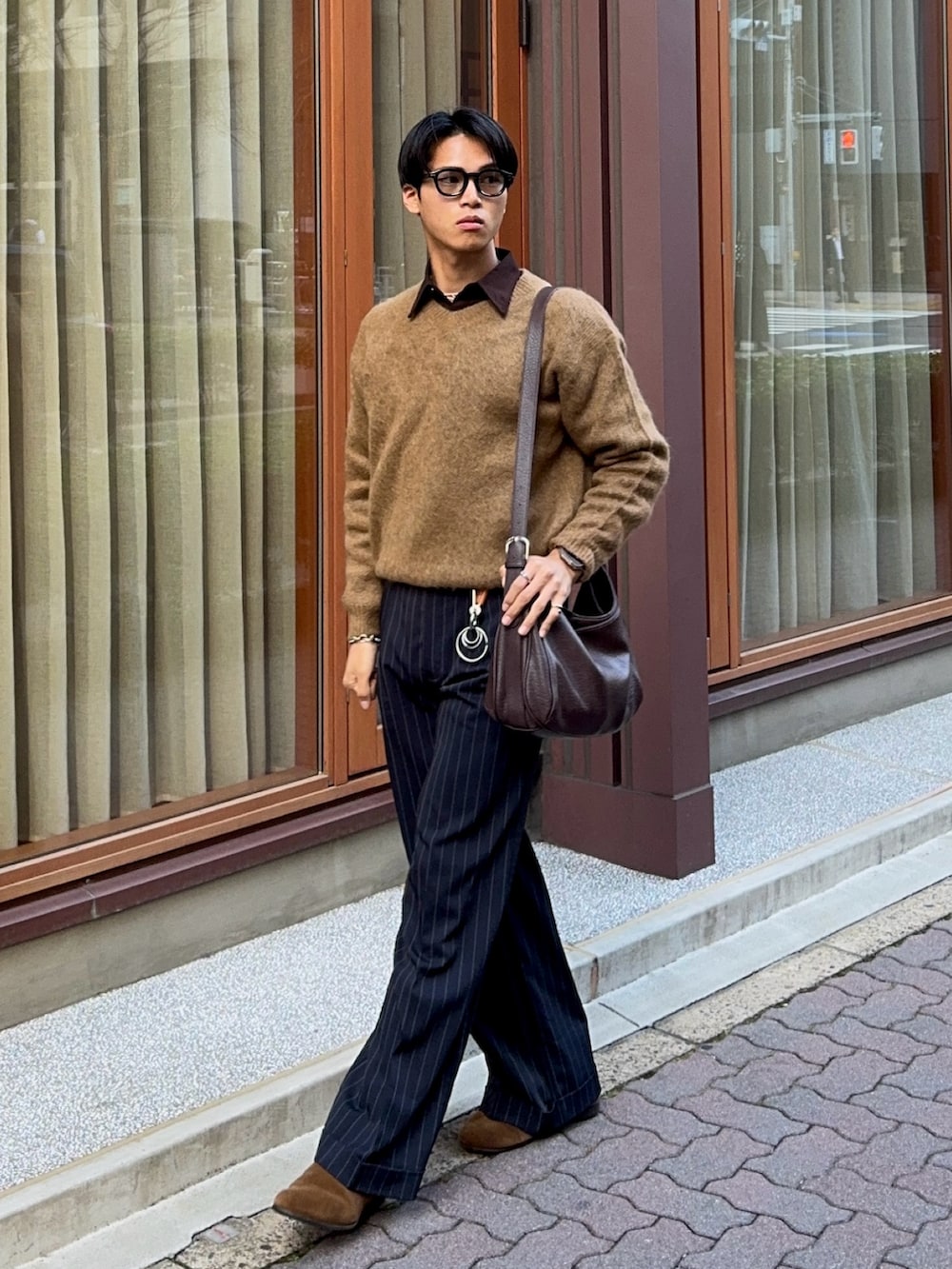 イエロー系のニット/セーター、ブラウン系のシャツ/ブラウス、ブラック系のスラックスを着用したメンズの春コーディネートの5枚目の写真