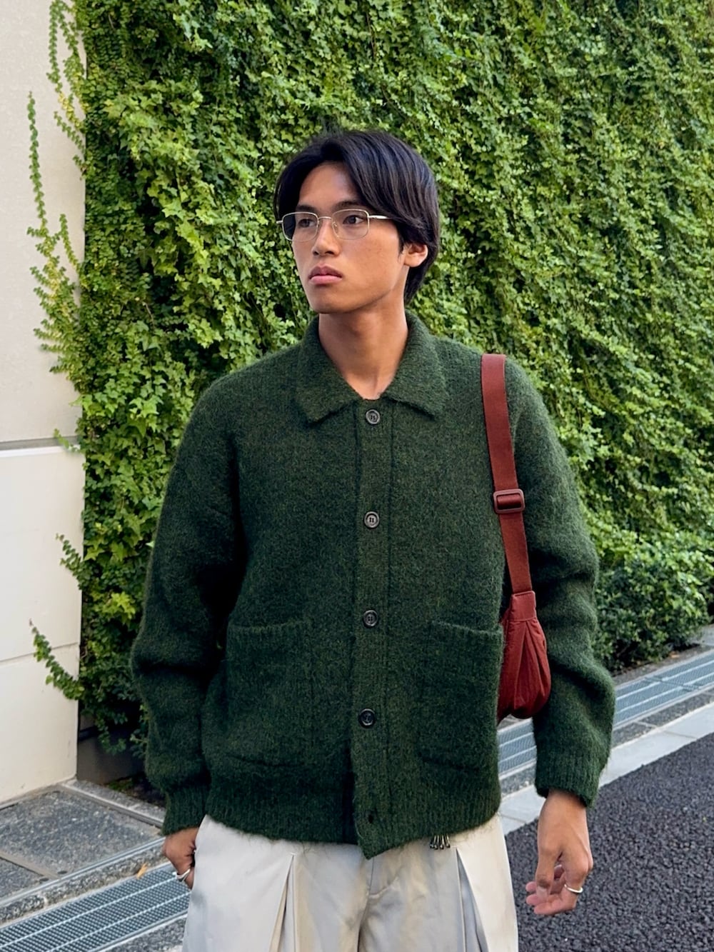 グリーン系のカーディガン/ボレロ、ブラック系のローファー、ホワイト系のスラックスを着用したメンズの秋コーディネートの2枚目の写真