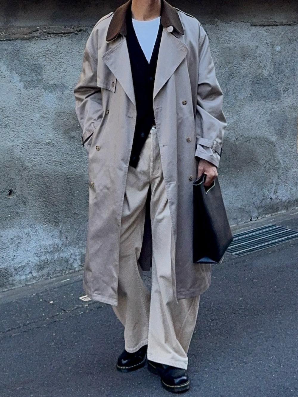 ブラック系のカーディガン/ボレロ、ベージュ系のトレンチコート、ベージュ系のスラックスを着用したメンズの冬コーディネートの4枚目の写真