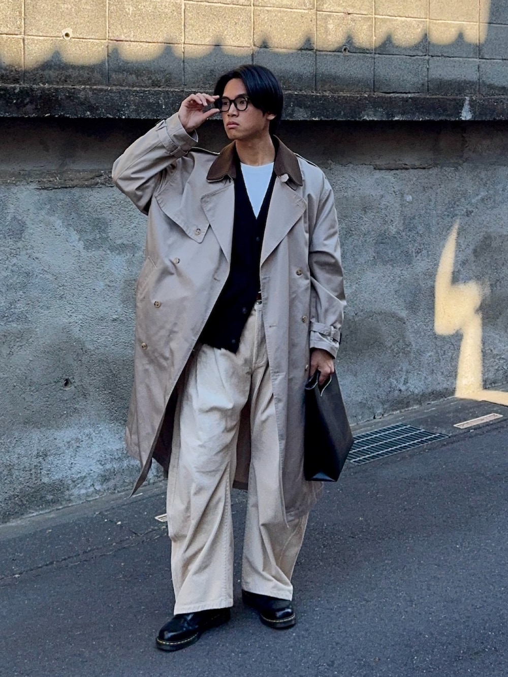 ブラック系のカーディガン/ボレロ、ベージュ系のトレンチコート、ベージュ系のスラックスを着用したメンズの冬コーディネートの5枚目の写真