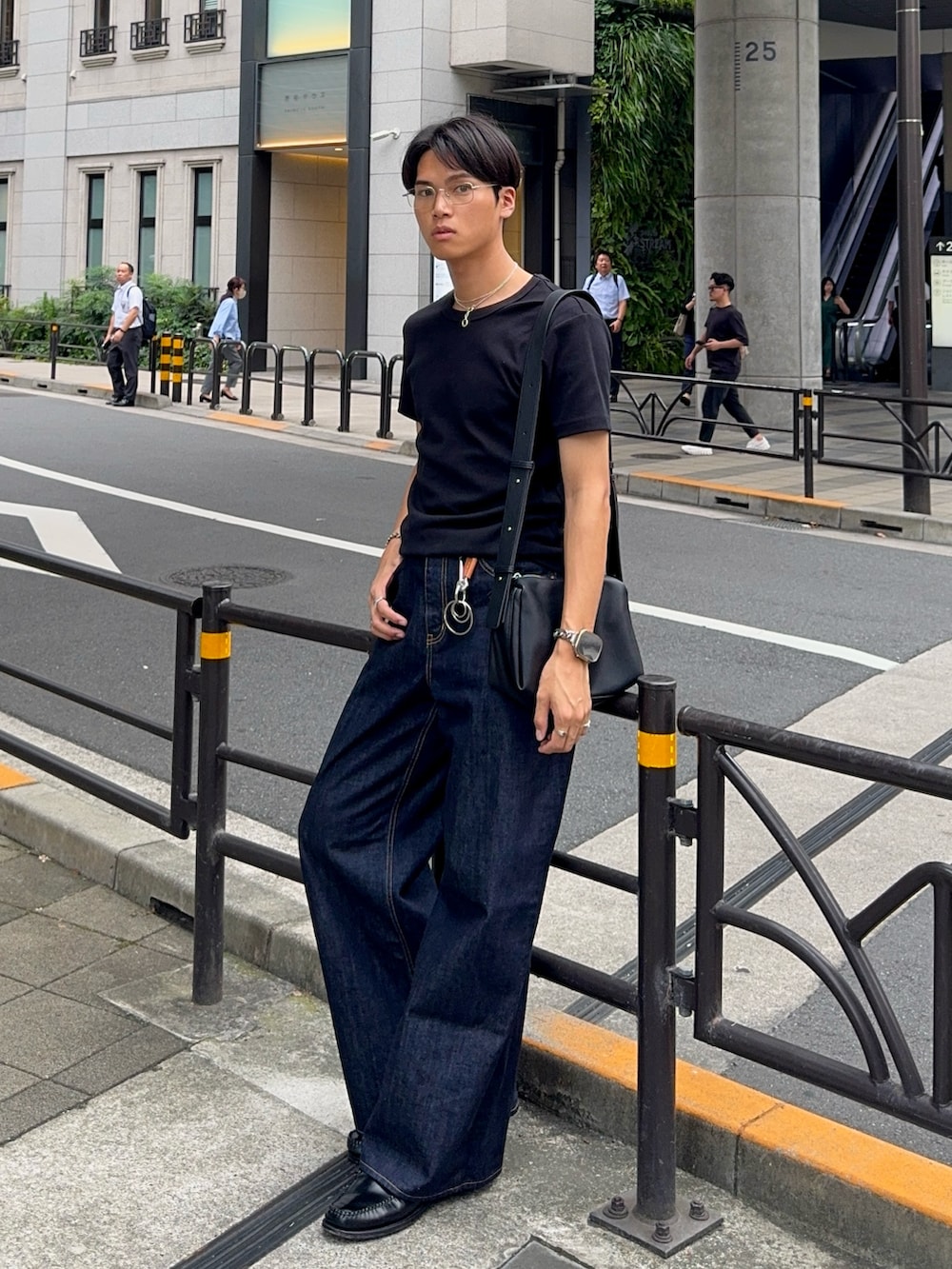 ブラック系のTシャツ/カットソー、ブルー系のデニムパンツ、ブラック系のローファーを着用したメンズの夏コーディネートの3枚目の写真