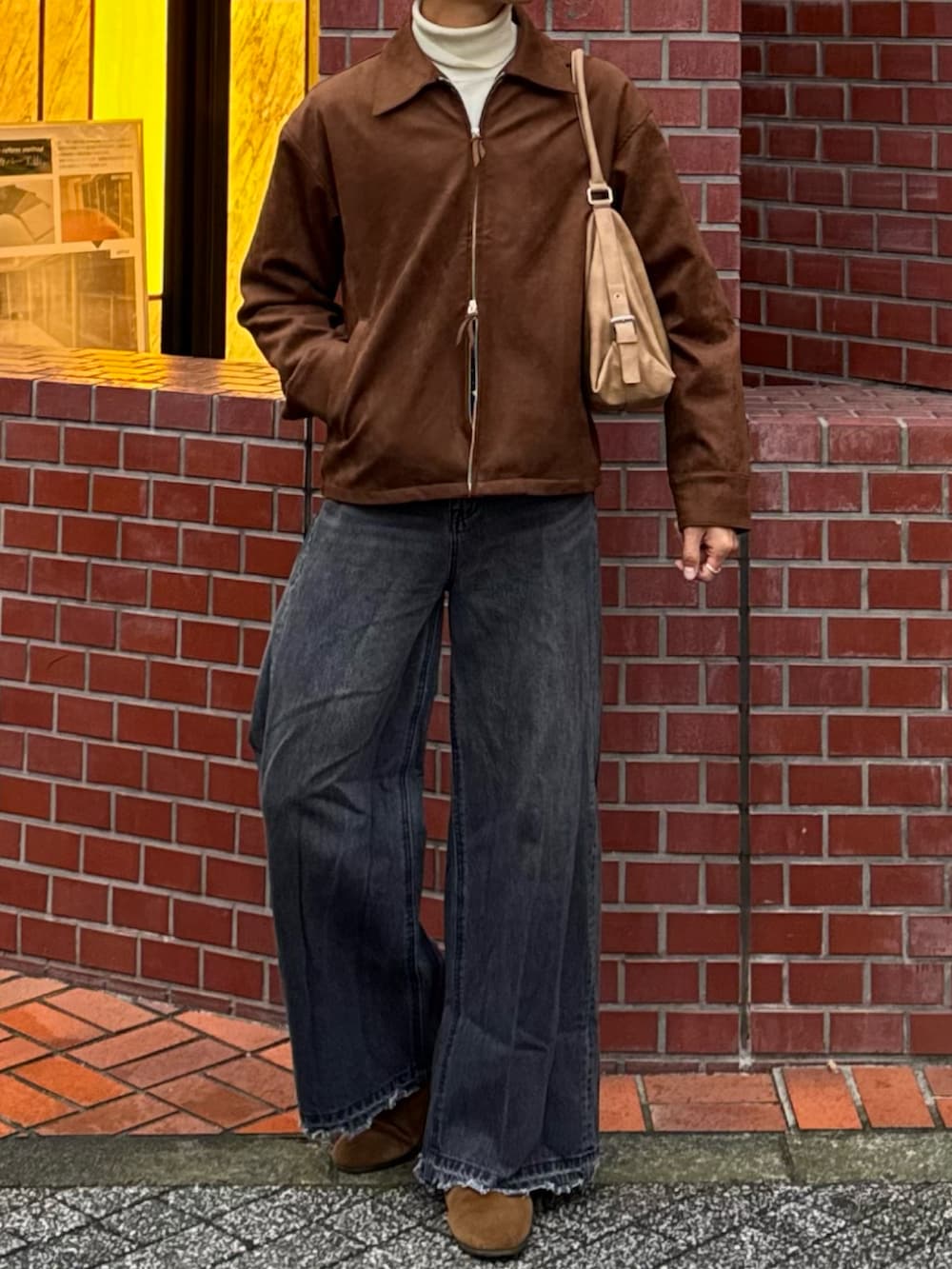 ブラウン系のブルゾン、ブラック系のデニムパンツ、ホワイト系のニット/セーターを着用したメンズの冬コーディネートの4枚目の写真