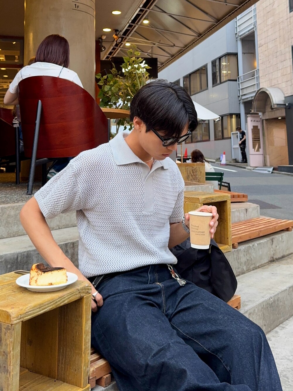 グレー系のポロシャツ、ブルー系のデニムパンツ、ブラック系のハンドバッグを着用したメンズの夏コーディネートの2枚目の写真