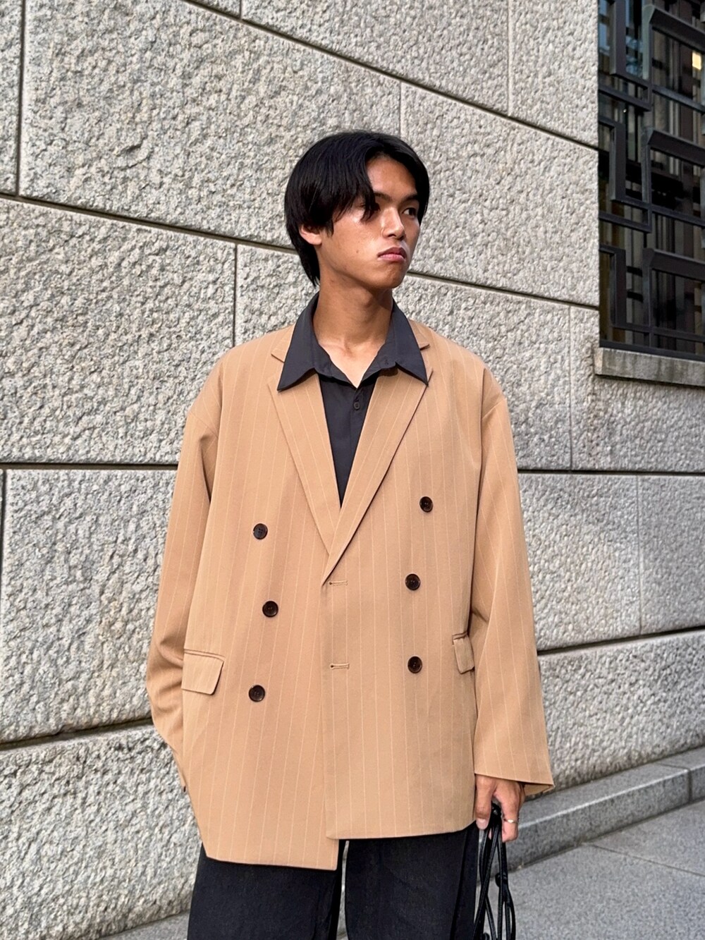 ブラック系のデニムパンツ、グレー系のシャツ/ブラウス、ベージュ系のテーラードジャケットを着用したメンズの秋コーディネートの2枚目の写真