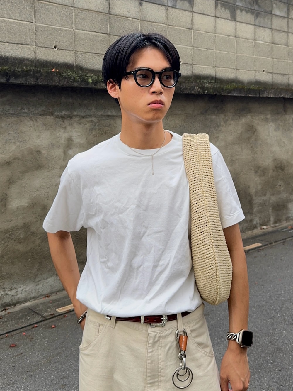 ホワイト系のTシャツ/カットソー、ホワイト系のデニムパンツ、ベージュ系のハンドバッグを着用したメンズの夏コーディネートの2枚目の写真