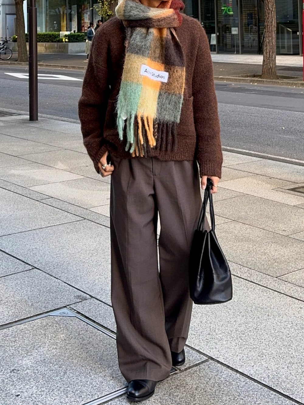 ブラウン系のスラックス、ブラック系のドレスシューズ、ブラウン系のカーディガン/ボレロを着用したメンズの冬コーディネートの4枚目の写真