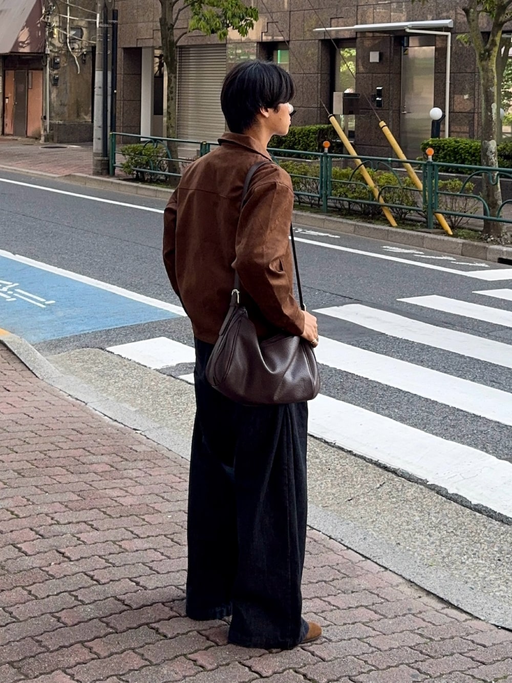 ブラウン系のブルゾン、ブラック系のその他パンツ、ブラウン系のショルダーバッグを着用したメンズの秋コーディネートの3枚目の写真
